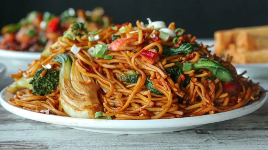 A white plate piled high with stir-fried noodles.
