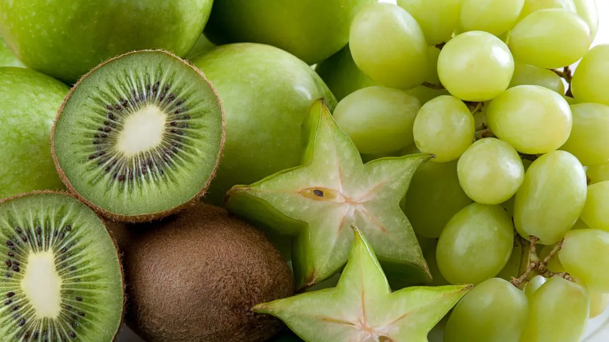 Various green fruits, including kiwi fruit, grapes, starfruit and green apples.