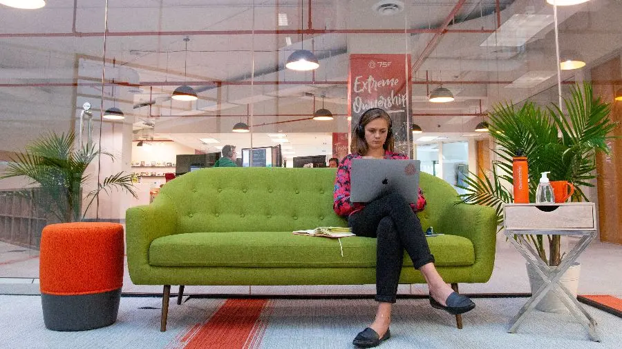 Woman working on a couch in a funky office space