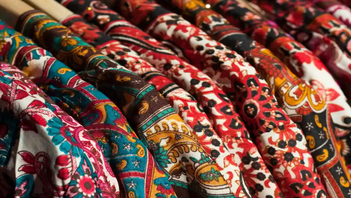 Colourful, patterned clothing on hangers.
