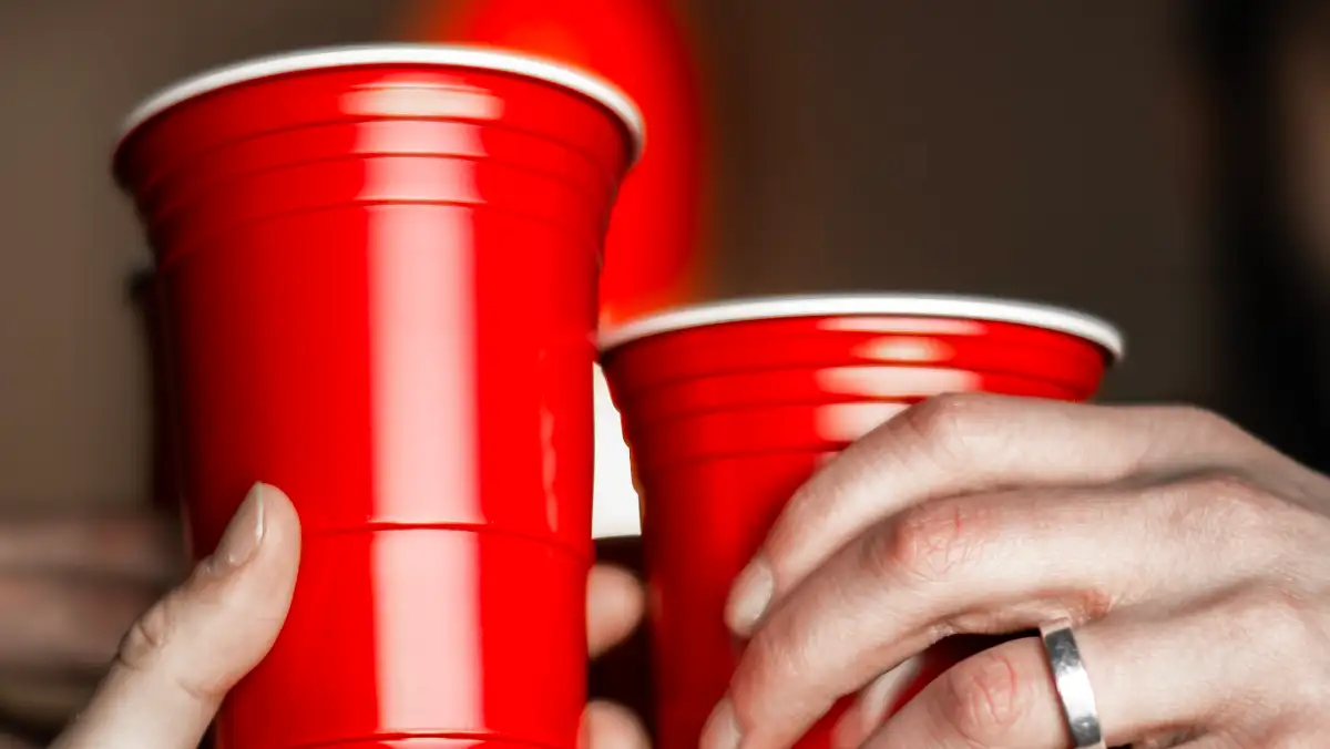 Hands cheering with red solo cups.