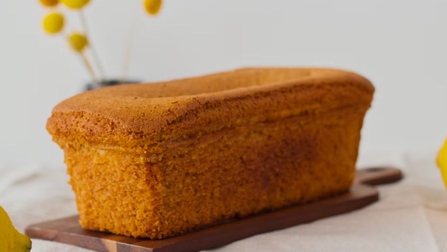 A loaf-shaped pound cake sitting on a wooden board.