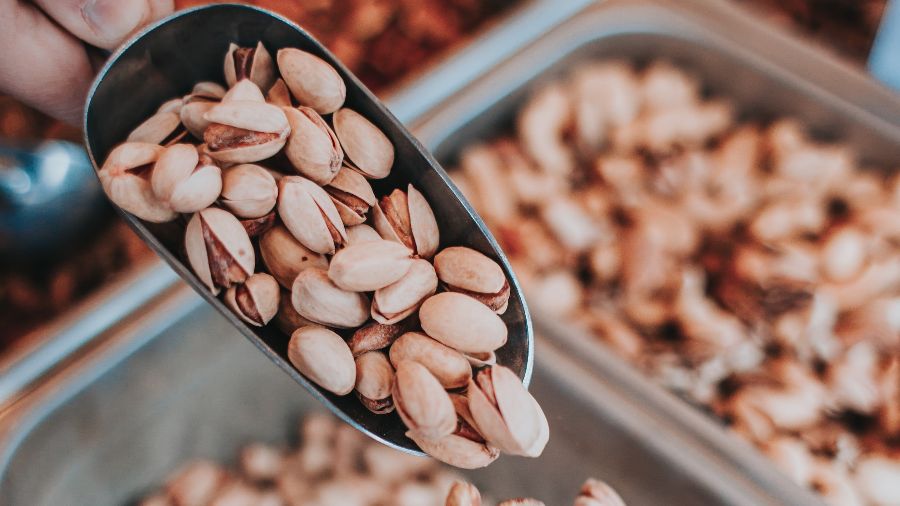 A metal scoop of pistachios