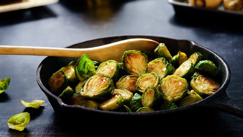 A cast iron skillet full of brussels sprouts.