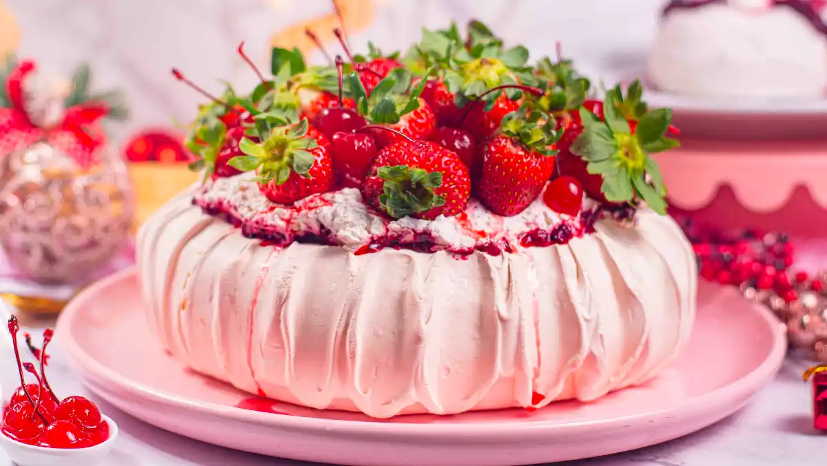 Pavlova with strawberries and cherries on top.