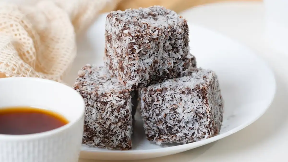 Plate of bite-sized lamingtons and a cup of tea.