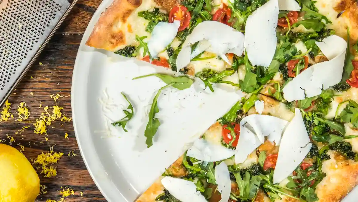 Pizza with rocket, tomato, cheese and lemon zest.
