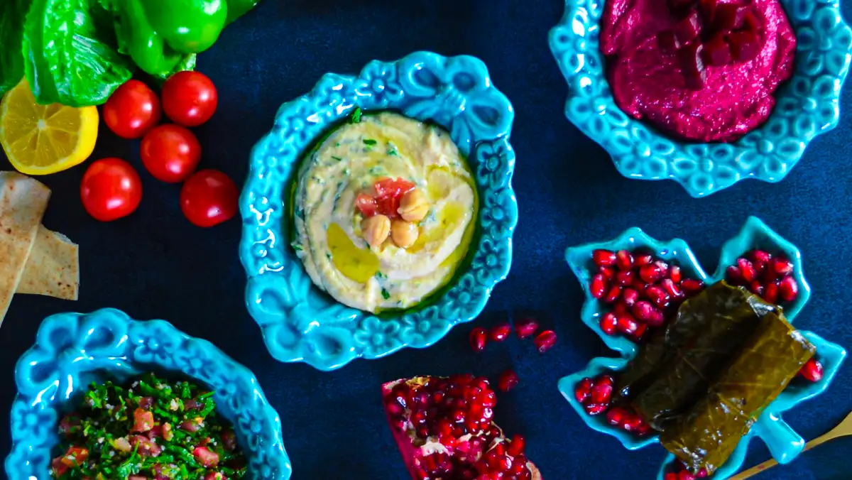 A selectio of Middle Eastern dips and dolmades in colourful bowls.