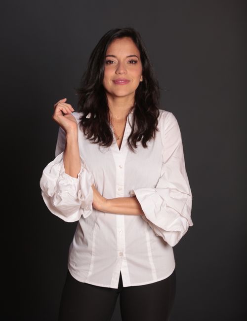 Coach nutricional Loana Duque sosteniendo su libro Y los vegetales pa' cuando