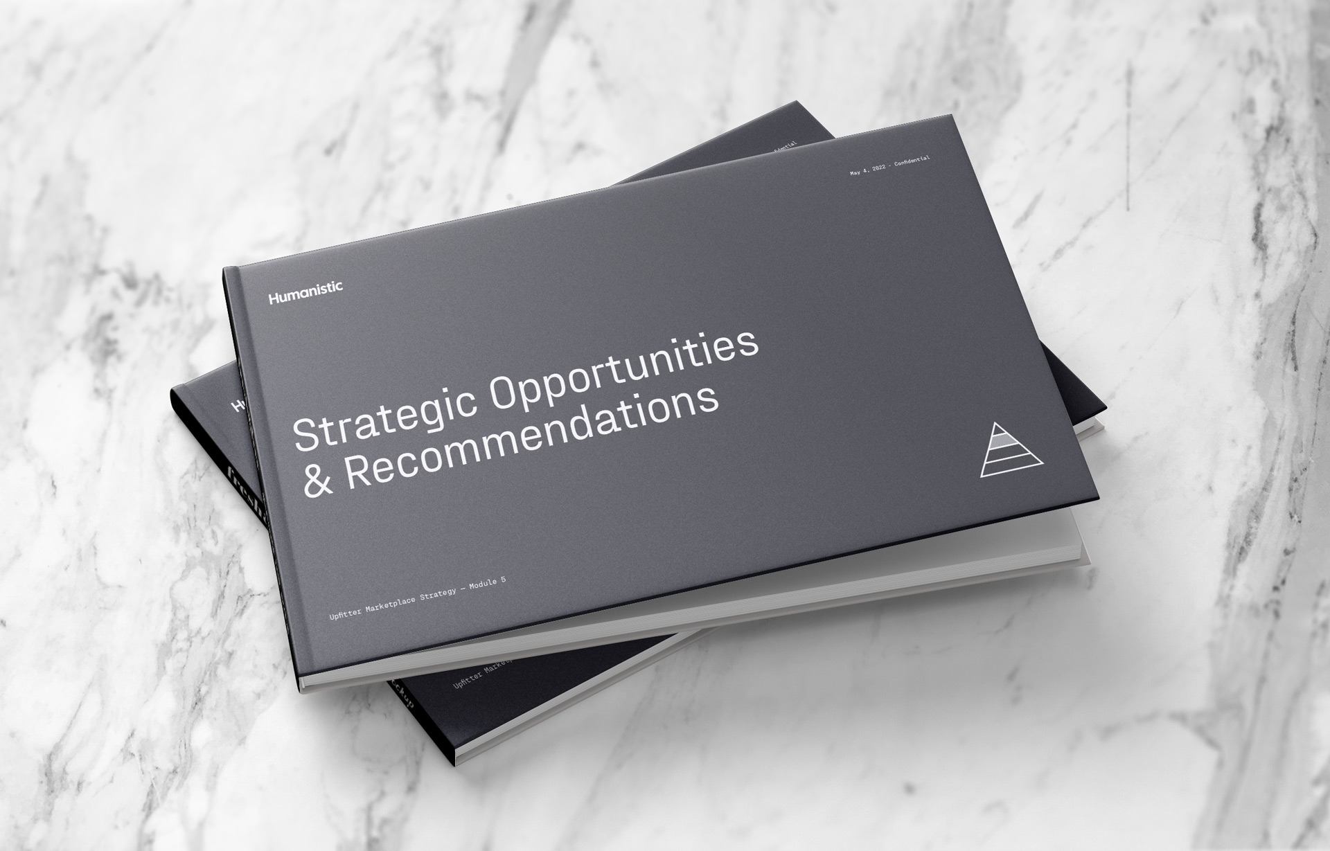 A pair of strategy books on a marble countertop