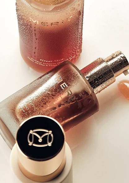 Three cosmetics bottles with condensation, one lying down with a pump dispenser and a black cap visible.