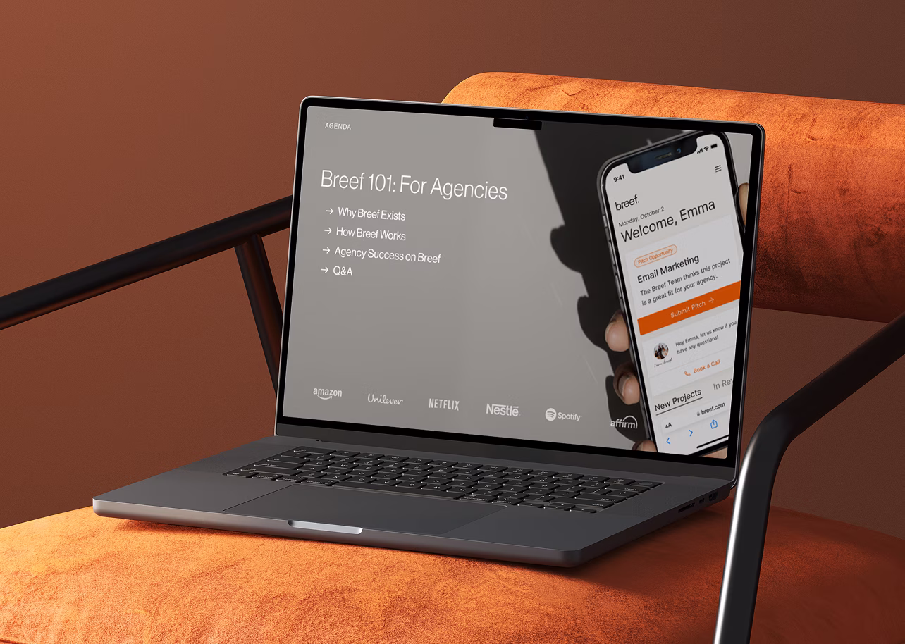 Laptop on an orange chair showing a presentation slide titled 'Breef 101: For Agencies' with agenda points and partner logos beneath. A hand holds a smartphone displaying a welcome message to Emma and an email marketing project within an app interface.
