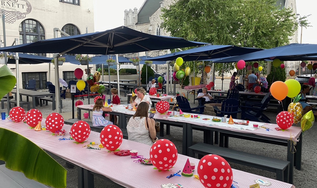 party balloons across tables and hanging from awning at the Partial Biergarten space