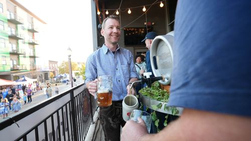 Nate Brinson in lederhosen with a stein of German beer in his hand