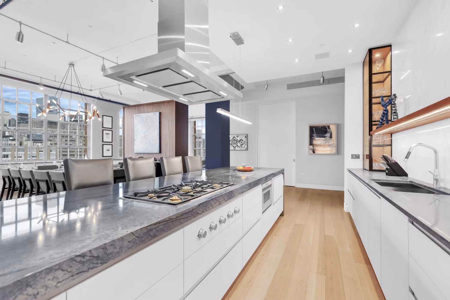 High-floor modern kitchen and dining area with a marble island and skyline view, from a Gallery KBNY renovation.