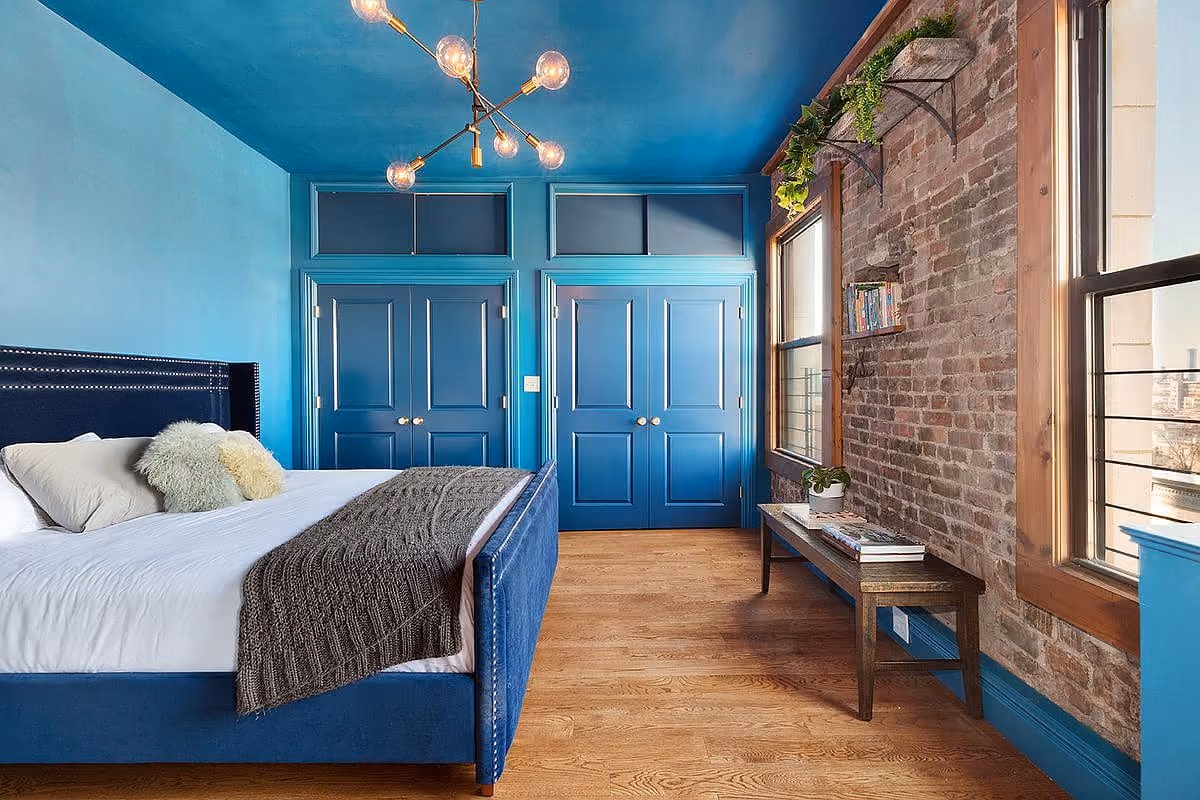 Bedroom with dark tones from a NYC apartment renovation by Gallery KBNY