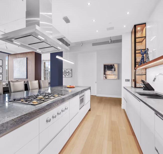 Renovated kitchen with two-tone cabinetry and marble countertops at Sky Lofts, 145 Hudson Street, in Tribeca, Manhattan, by Gallery KBNY