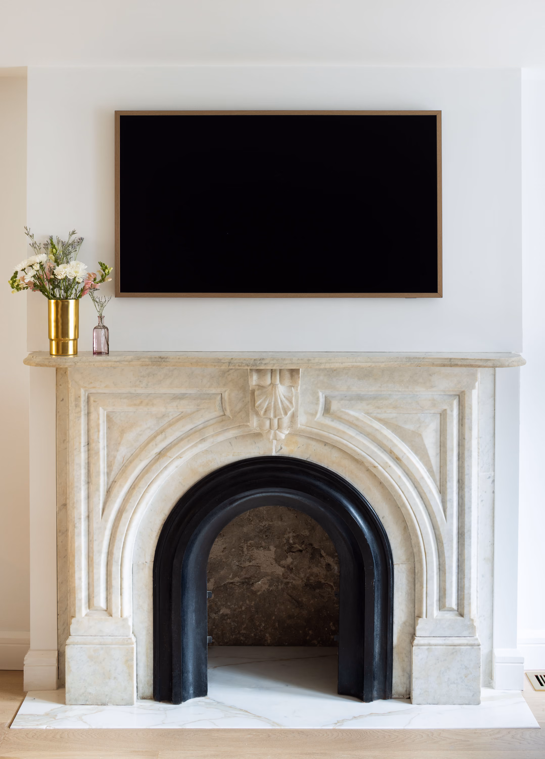 Restored marble mantel with mounted television in a Carroll Gardens brownstone at 347 President Street, Brooklyn, by Gallery KBNY