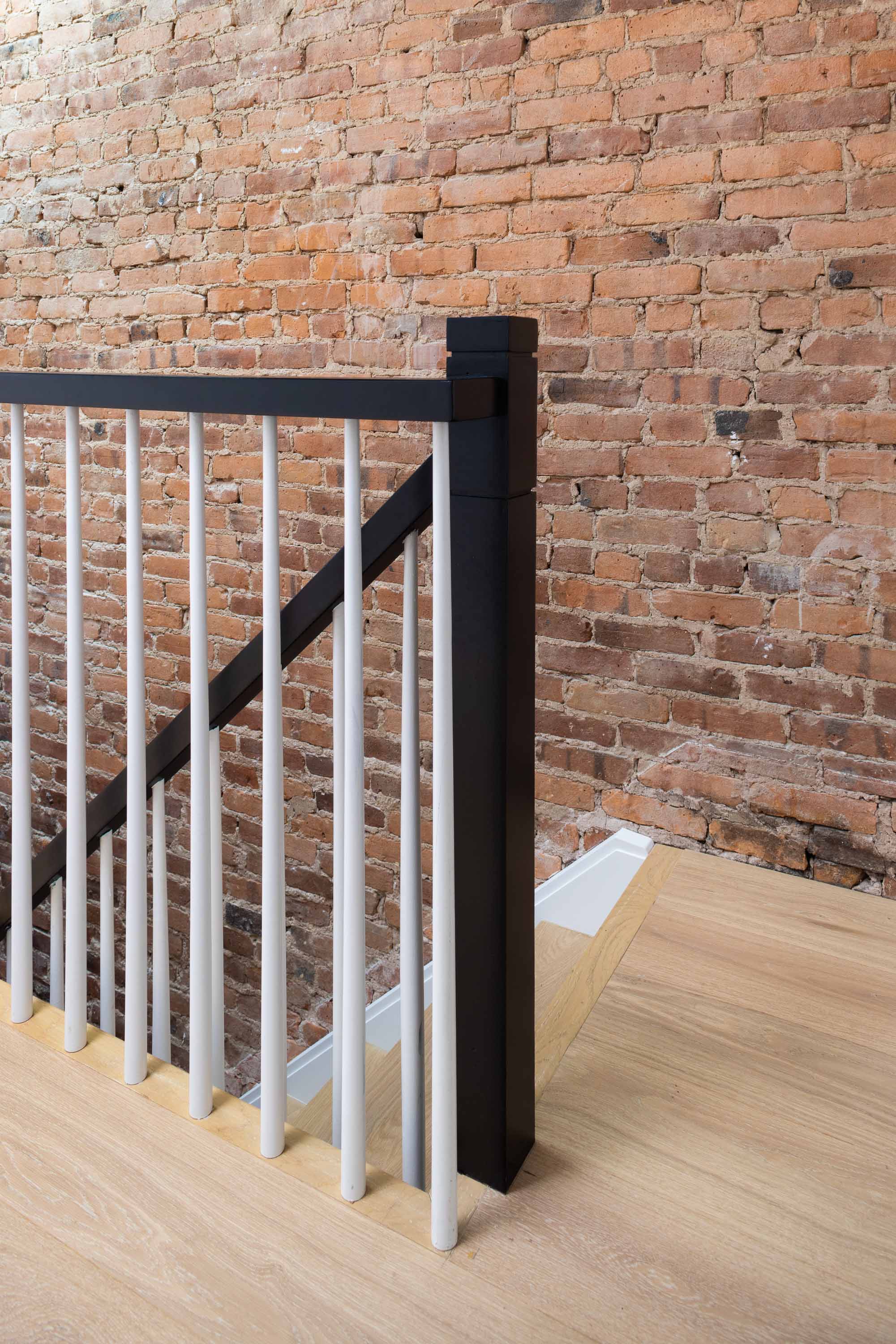 Restored staircase against exposed brick in a Carroll Gardens brownstone at 347 President Street, Brooklyn, by Gallery KBNY
