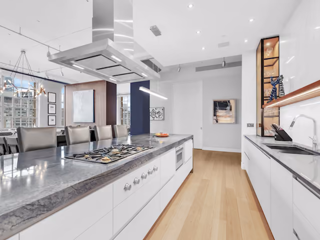 Renovated kitchen with professional range and island seating at Sky Lofts, 145 Hudson Street, in Tribeca, Manhattan, by Gallery KBNY