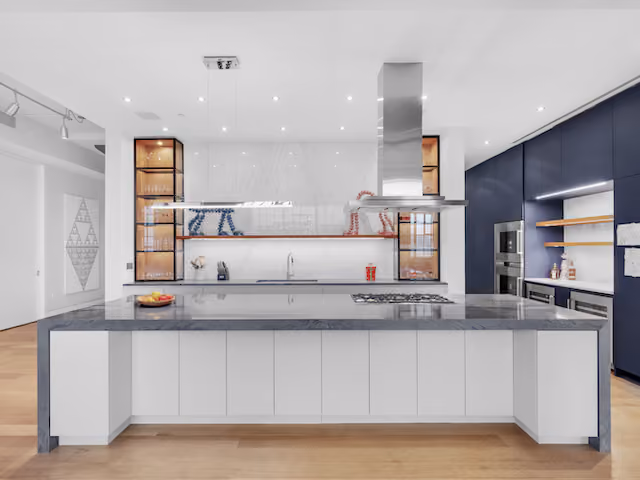 Kitchen island with waterfall marble and open shelving at Sky Lofts, 145 Hudson Street, in Tribeca, Manhattan, by Gallery KBNY