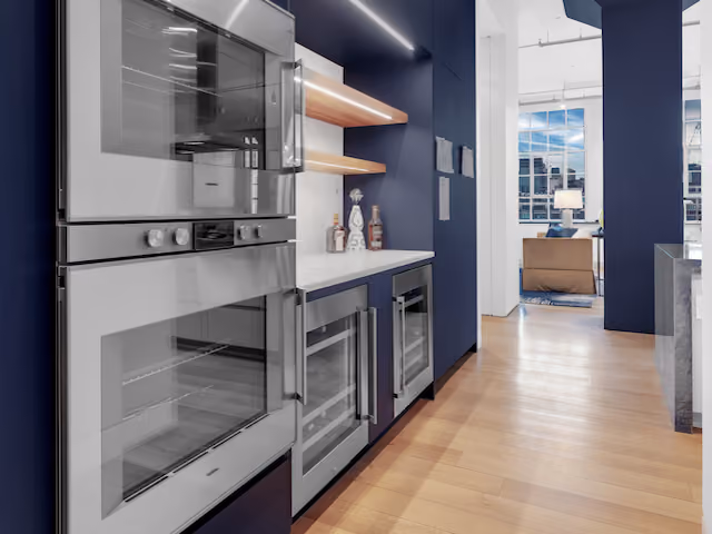 Built-in wall ovens with blue cabinetry at Sky Lofts, 145 Hudson Street, in Tribeca, Manhattan, by Gallery KBNY