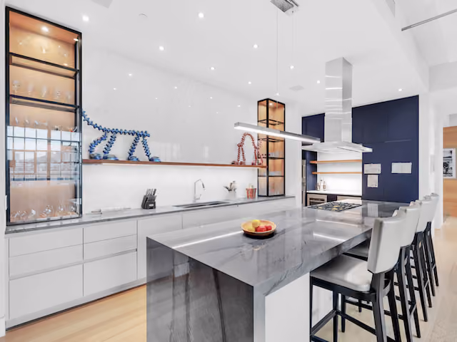 Open loft kitchen and dining area with industrial windows at Sky Lofts, 145 Hudson Street, in Tribeca, Manhattan, by Gallery KBNY