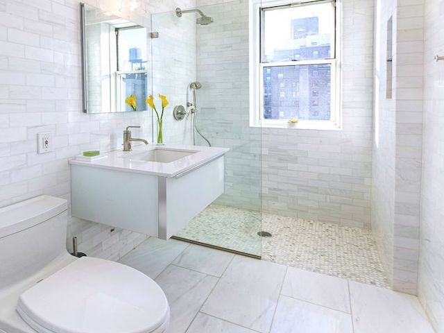 Bathroom with marble subway tile, glass-enclosed shower and floating vanity in a pre-war co-op at 895 West End Avenue by Gallery KBNY