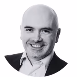 Portrait of a smiling bald man wearing a suit jacket and white shirt.