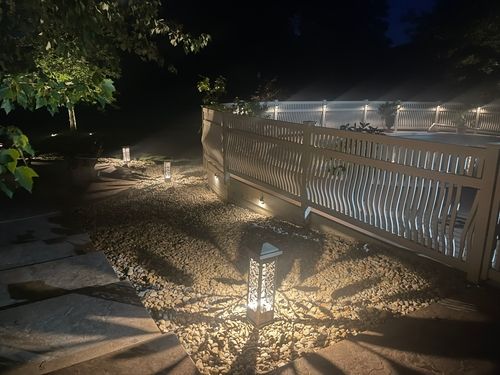Backyard patio with soft landscape lighting creating a cozy nighttime atmosphere.