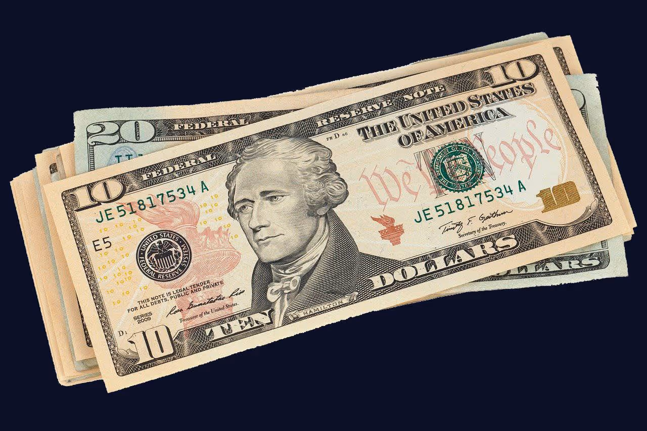 Stack of U.S. dollar bills with a $10 bill featuring Alexander Hamilton on top and a $20 bill beneath.