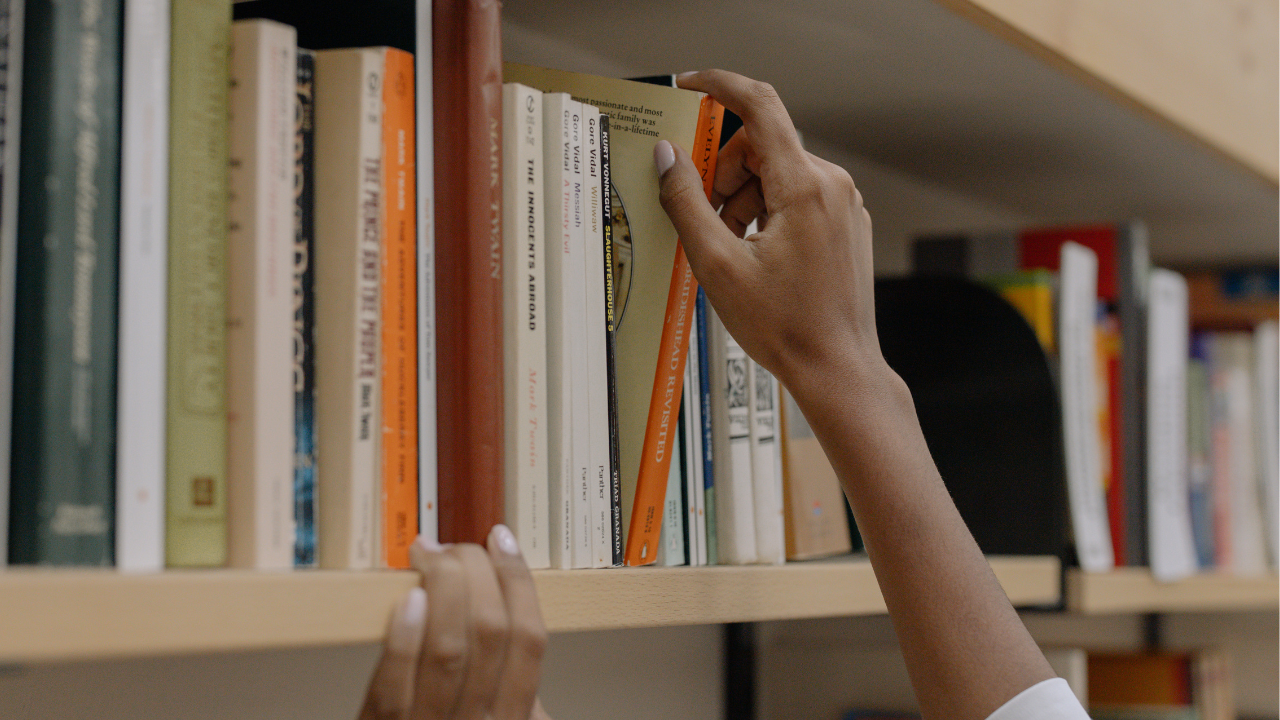 A library patron reaches for a book at the library. 