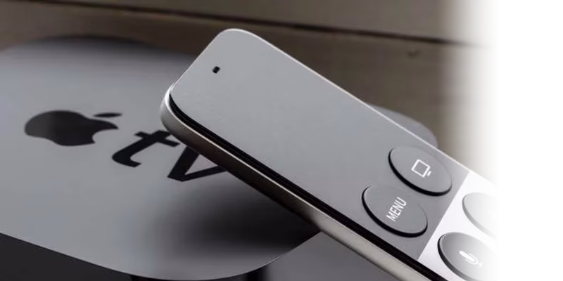 An apple tv with a remote next to it.