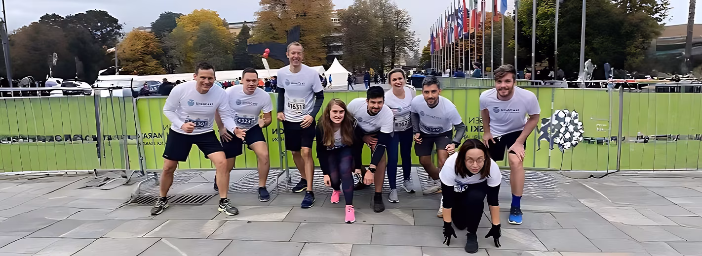 A group of people posing for a picture in front of a fence.