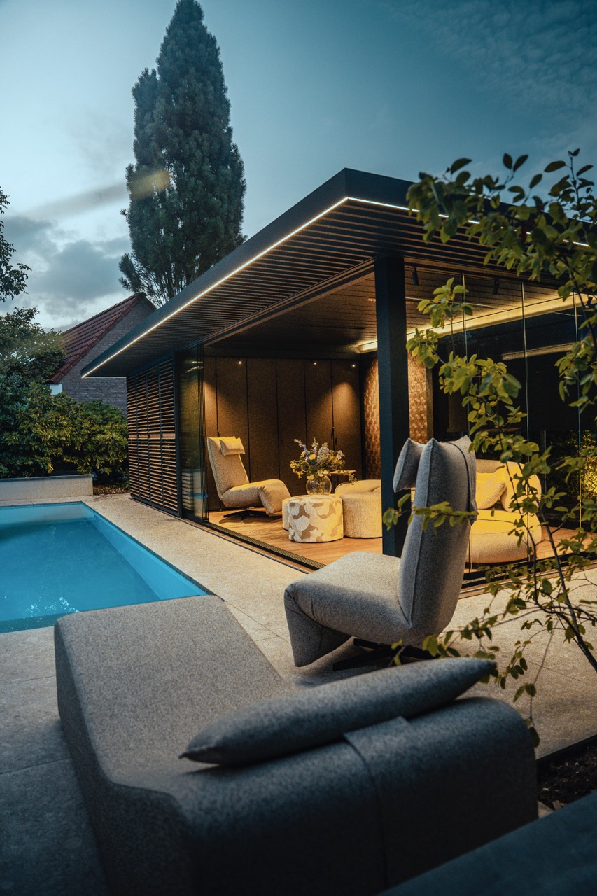 Modern tuinpaviljoen met zwembad en gezellige zithoek bij schemering