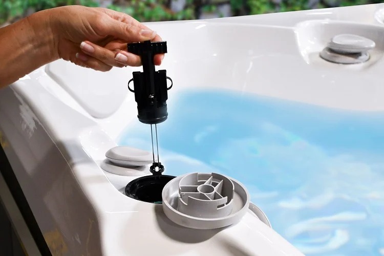 Hand plaatst FreshWater zoutwatersysteem-cartridge in een spa
