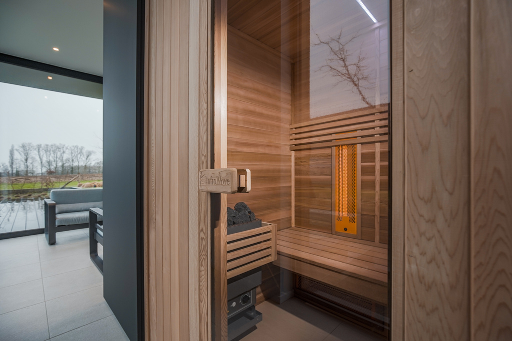 Moderne houten sauna met groot raam en uitzicht op winterlandschap