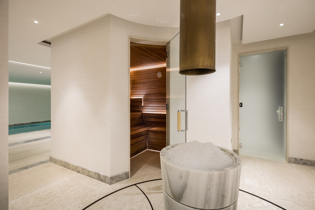 Moderne spa met houten sauna, marmeren bad en design afzuigkap