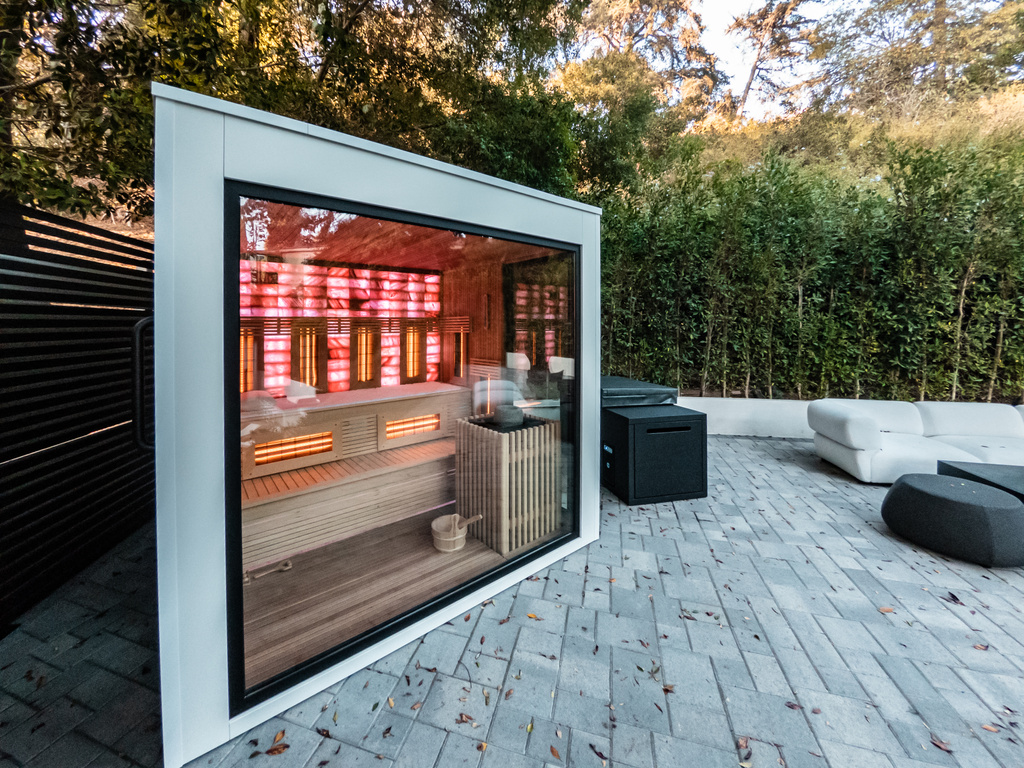 Moderne infrarood sauna met glazen wand in groene buitenomgeving
