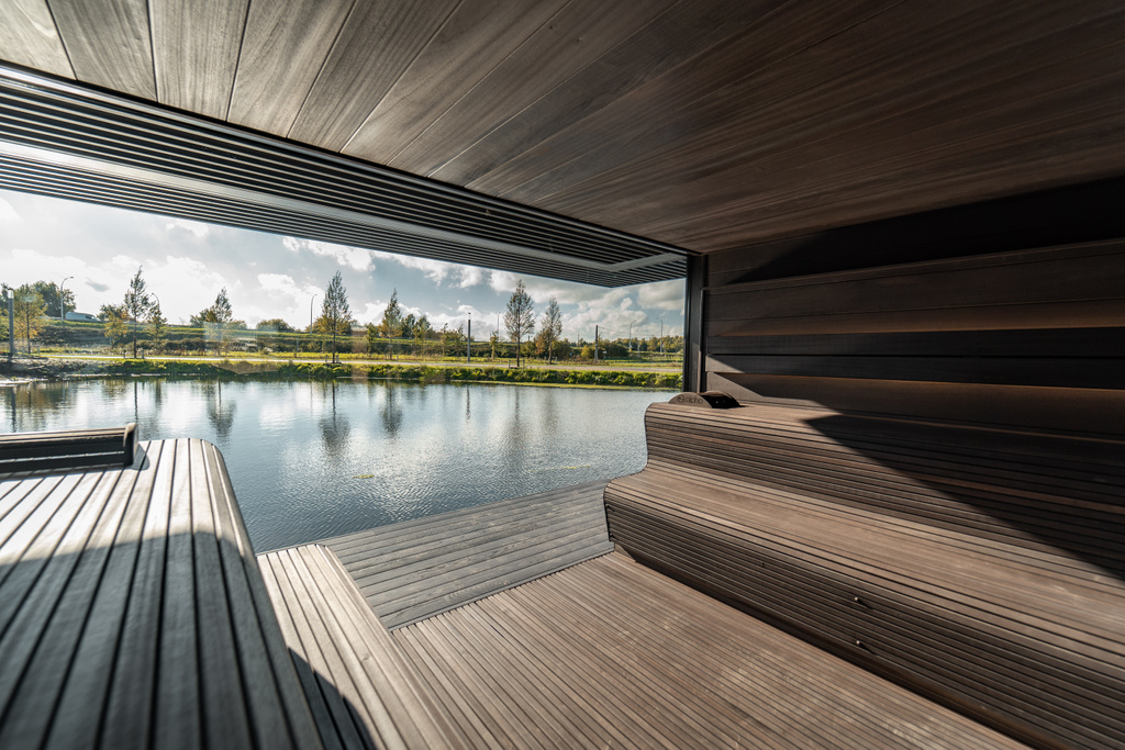 Houten overdekt terras met uitzicht op rustige vijver met bomen