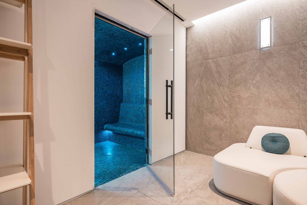 Moderne blauwe stoomcabine met glazen deur in strak ingerichte badkamer