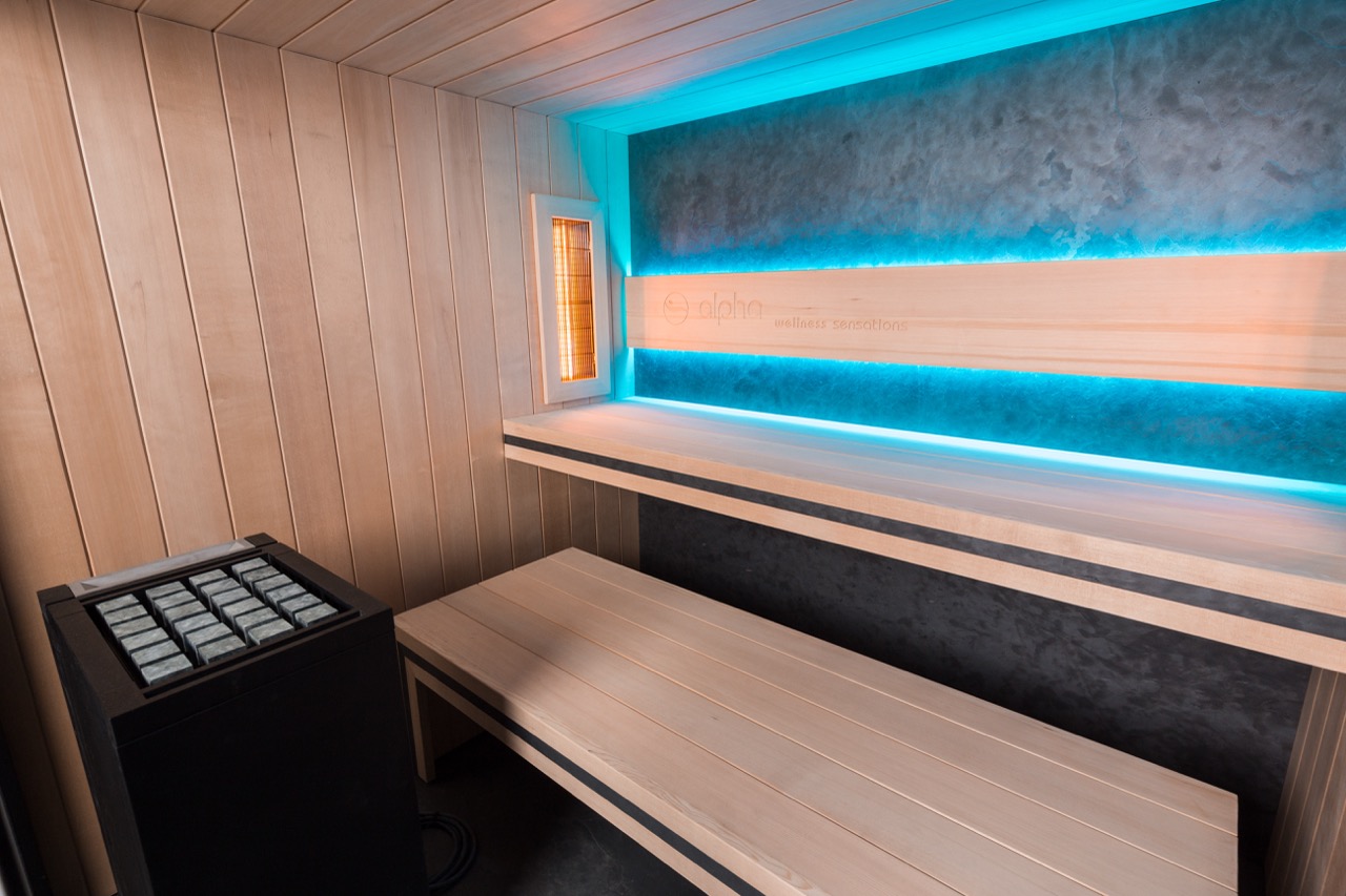 Moderne sauna met blauwe verlichting en houten bank in strakke ruimte