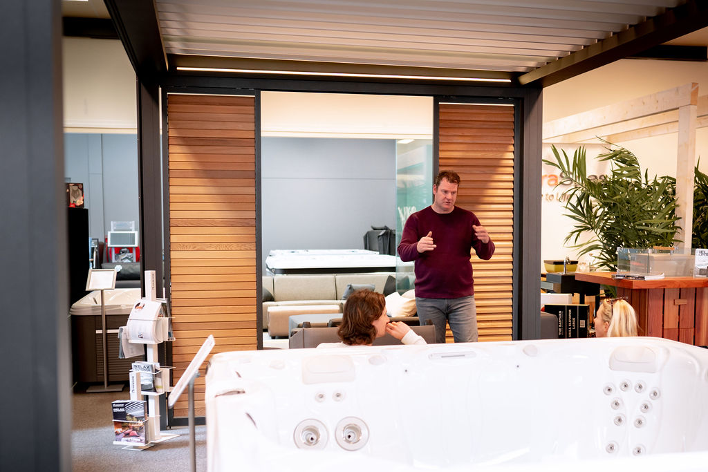 Showroom met hottub en adviseur die presentatie geeft aan klanten