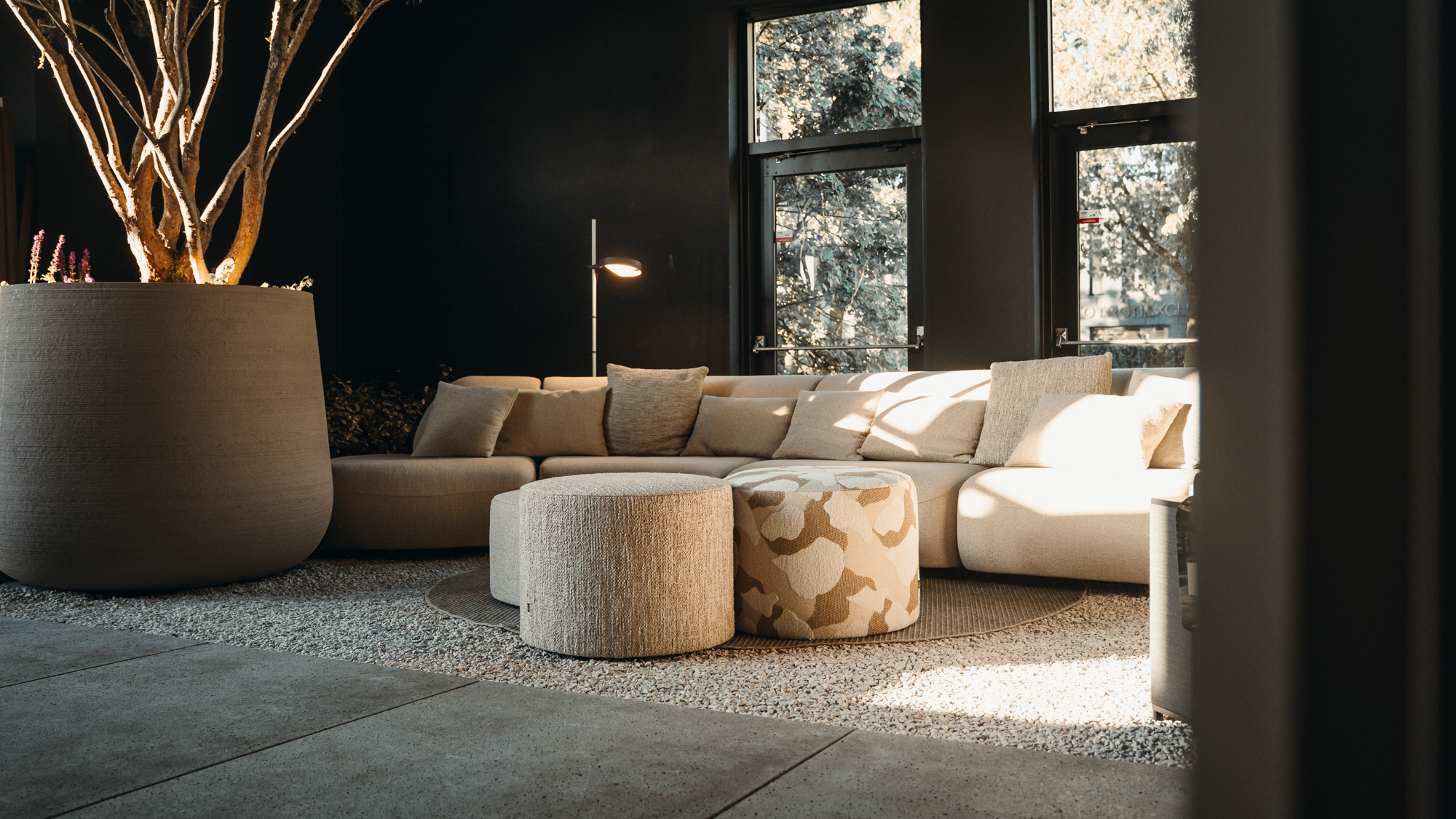 Moderne loungebank met zonnig licht, zachte bank en decoratieve krukken