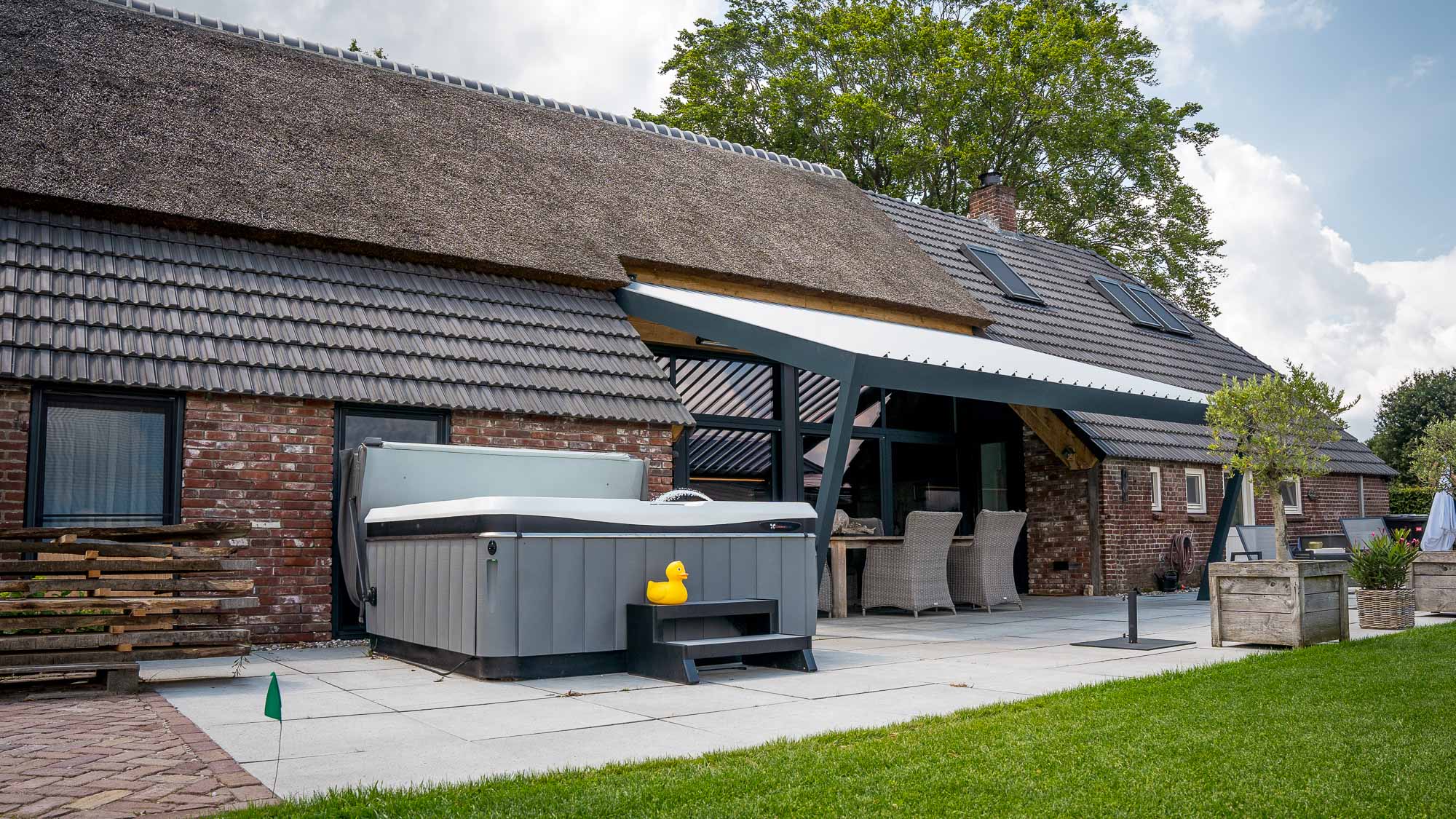 Renson-overkapping met hottub en gele eend op een gezellig terras
