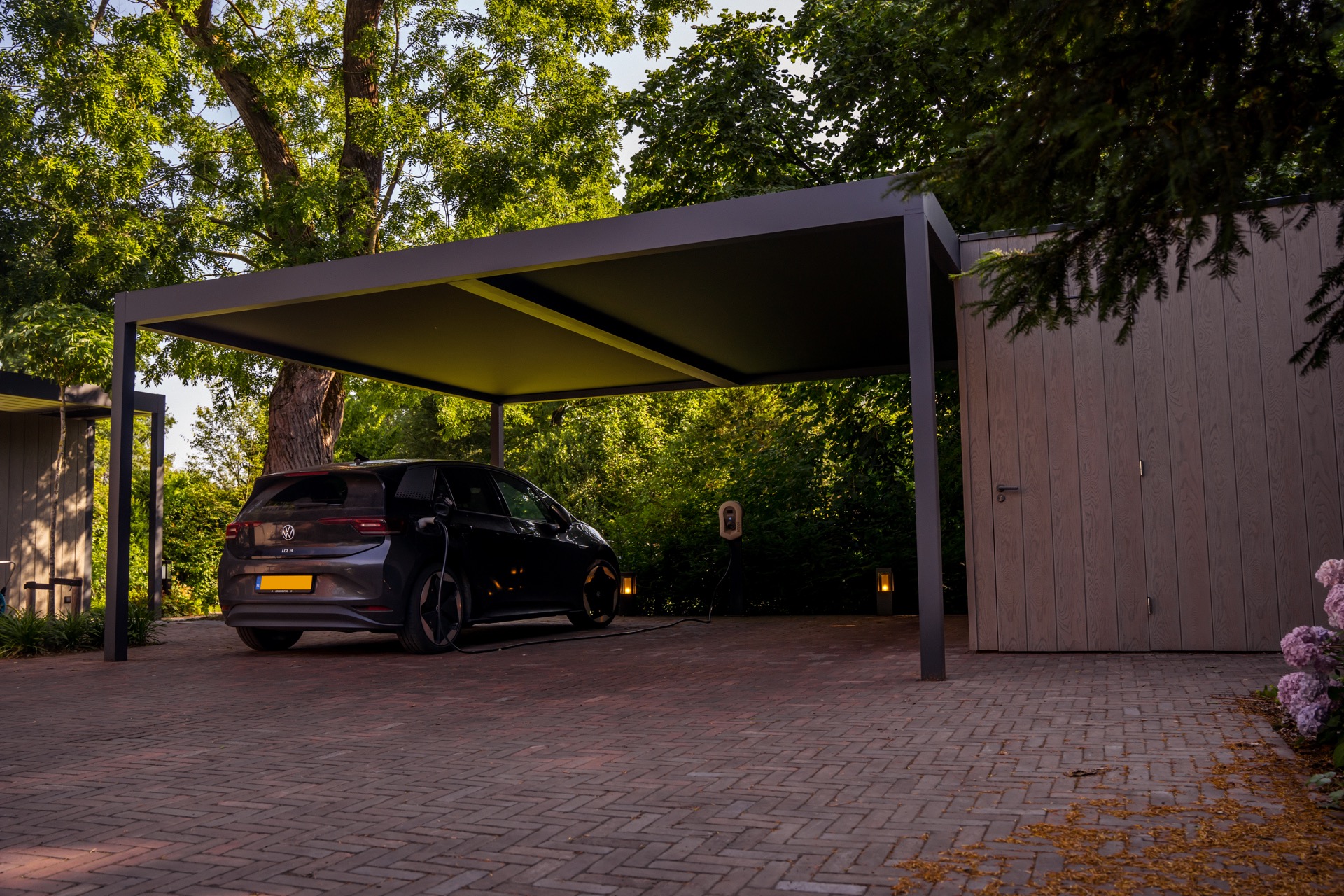 Moderne Renson-carport met elektrische Volkswagen bij zonsondergang