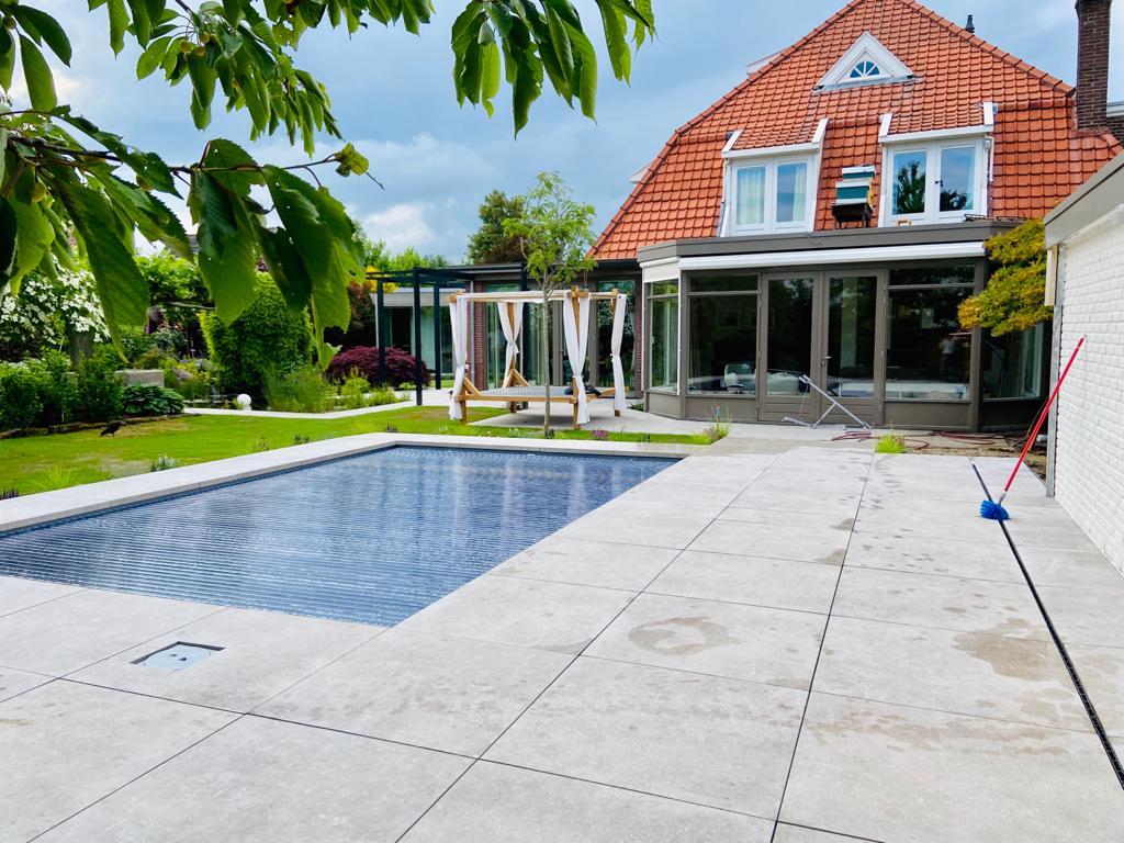 Moderne zwembad met relaxplek in groene outdoor tuin bij huis