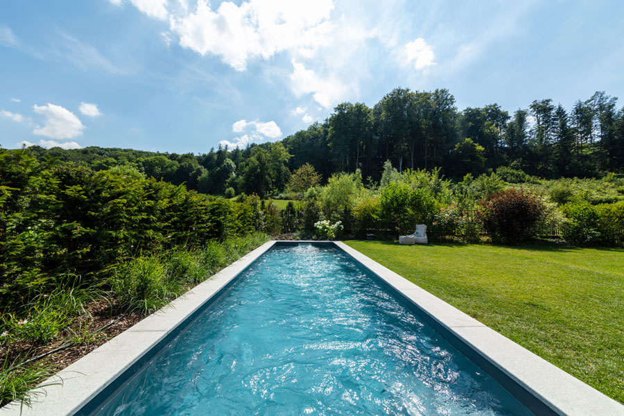 Rustige outdoor zwembad met groene bomen en gras voor ontspanning
