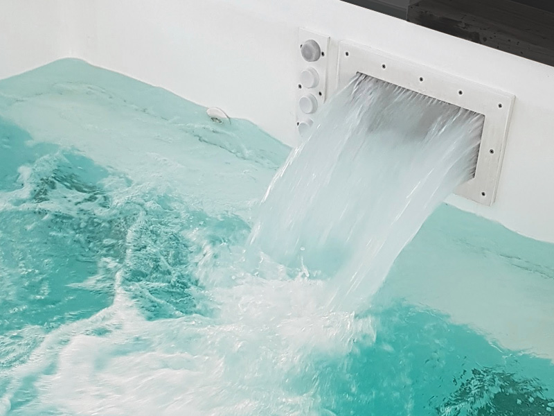 Rustgevende outdoor zwembad met waterval, perfect om te relaxen