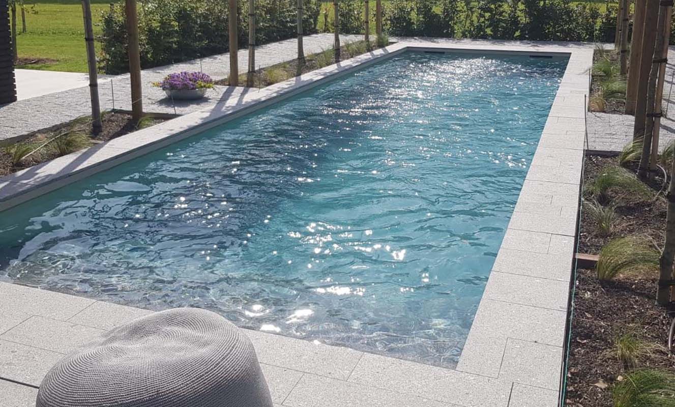 Rustgevende buitenzwembad met fonkelend water en ontspannen omgeving